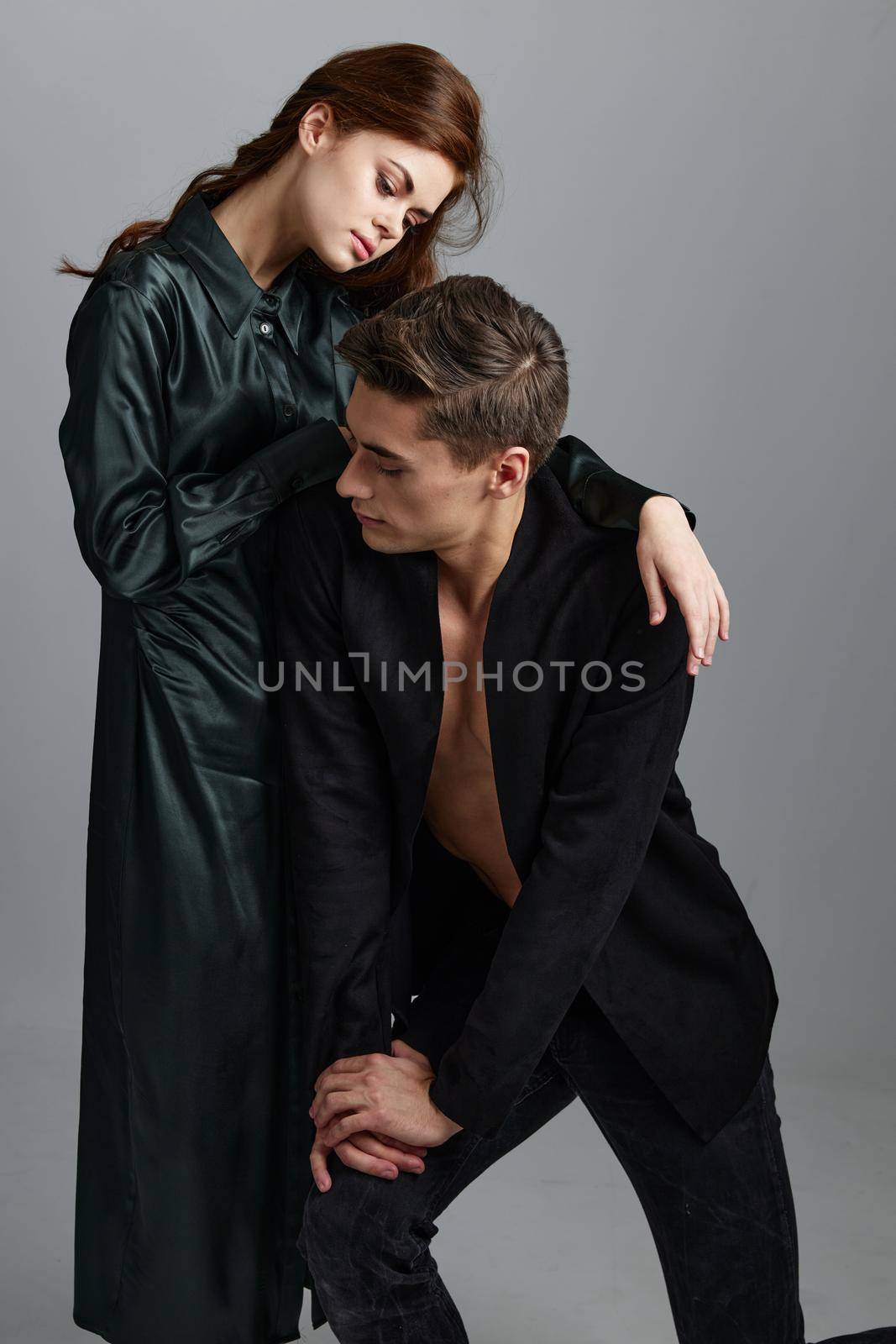 a man bent down and a woman in an evening dress on a gray background by SHOTPRIME