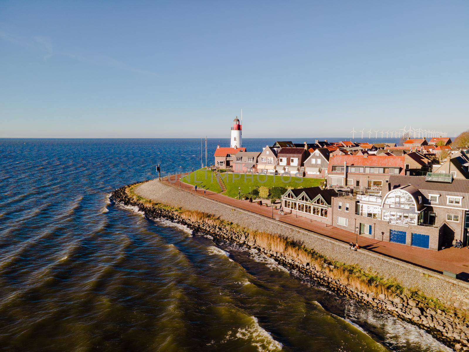 Urk lighthouse with old harbor during sunset, Urk is a small village by the lake Ijsselmeer in the Netherlands Flevoland area. beach and harbor of Urk November 2020