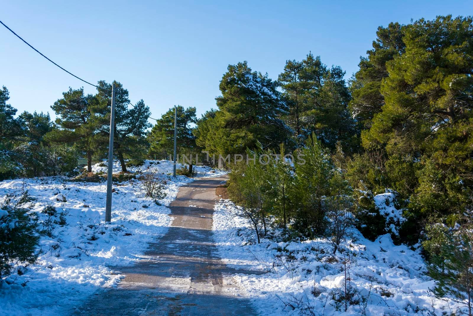 Road winter scene in the snowy landscape at mountain forest, Parnitha, Greece.