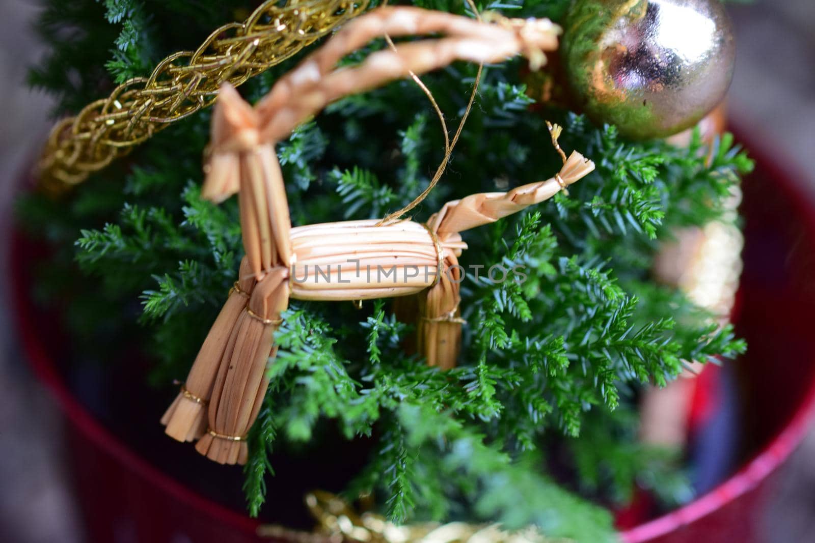 Close up of a straw horse at a small decorated christmas tree