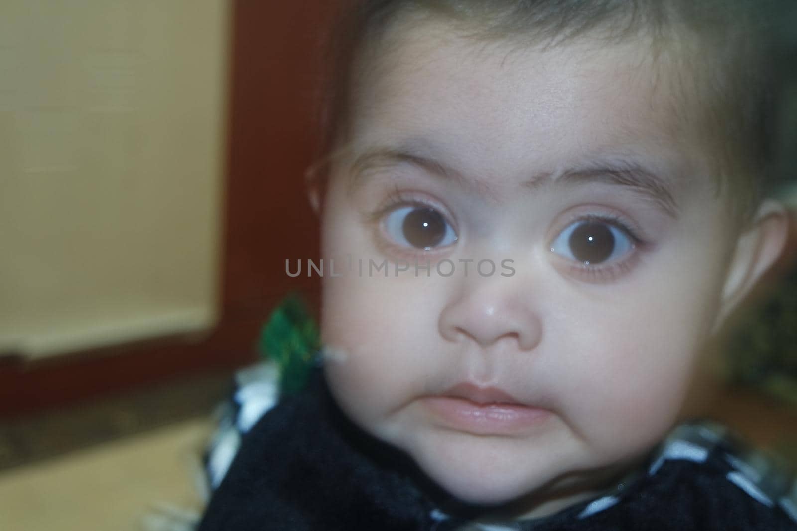 Baby girl with lovely face, big eyes and cute face gesture. Toddler baby making sweet activities