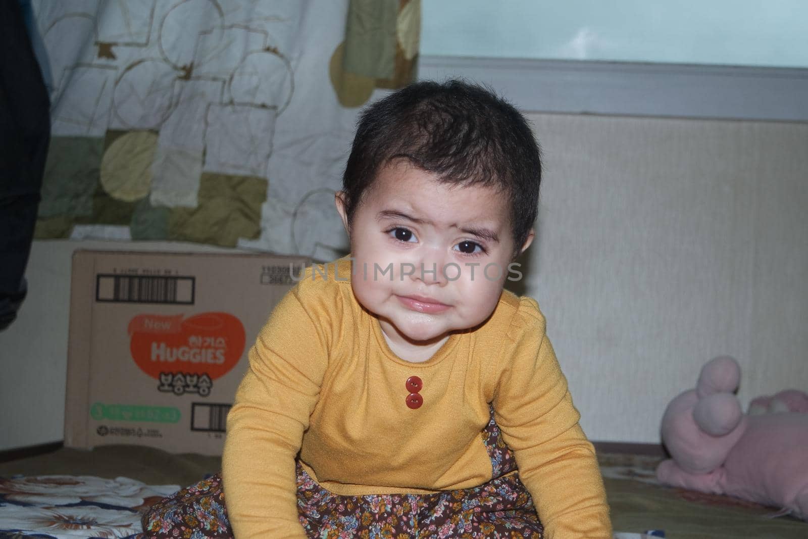 Baby girl with lovely face, big eyes and cute face gesture. Toddler baby making sweet activities