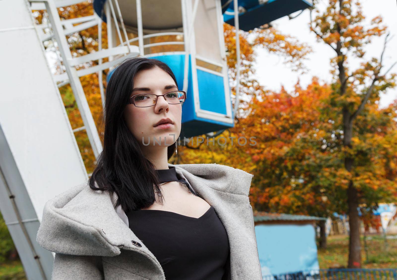 portrait of young girl standing in city park on autumn day