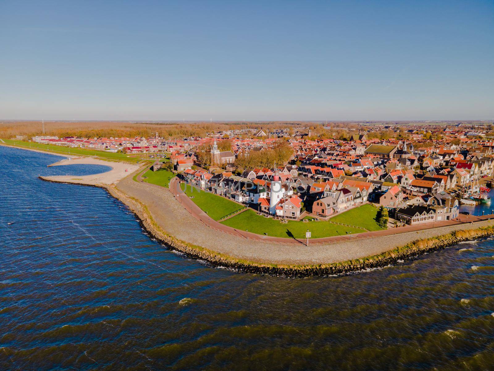 Urk lighthouse with old harbor during sunset, Urk is a small village by the lake Ijsselmeer in the Netherlands Flevoland area. beach and harbor of Urk