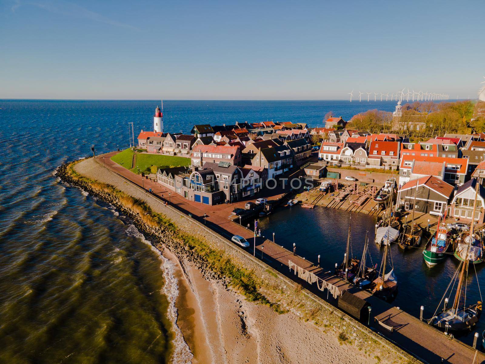 Urk lighthouse with old harbor during sunset, Urk is a small village by the lake Ijsselmeer in the Netherlands Flevoland area. beach and harbor of Urk