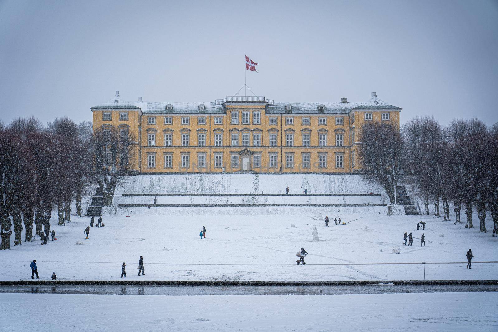 Copenhagen, Denmark - January 06, 2021: People enjoying a snowy winter day in front of the palace in Frederiksberg Gardens