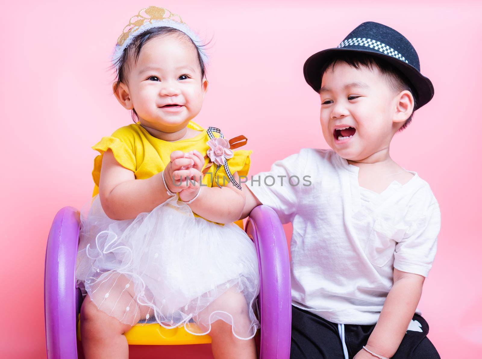 Asian Little brother and her baby girl in beautiful dress sitting on chair,  Family with children in studio on pink background