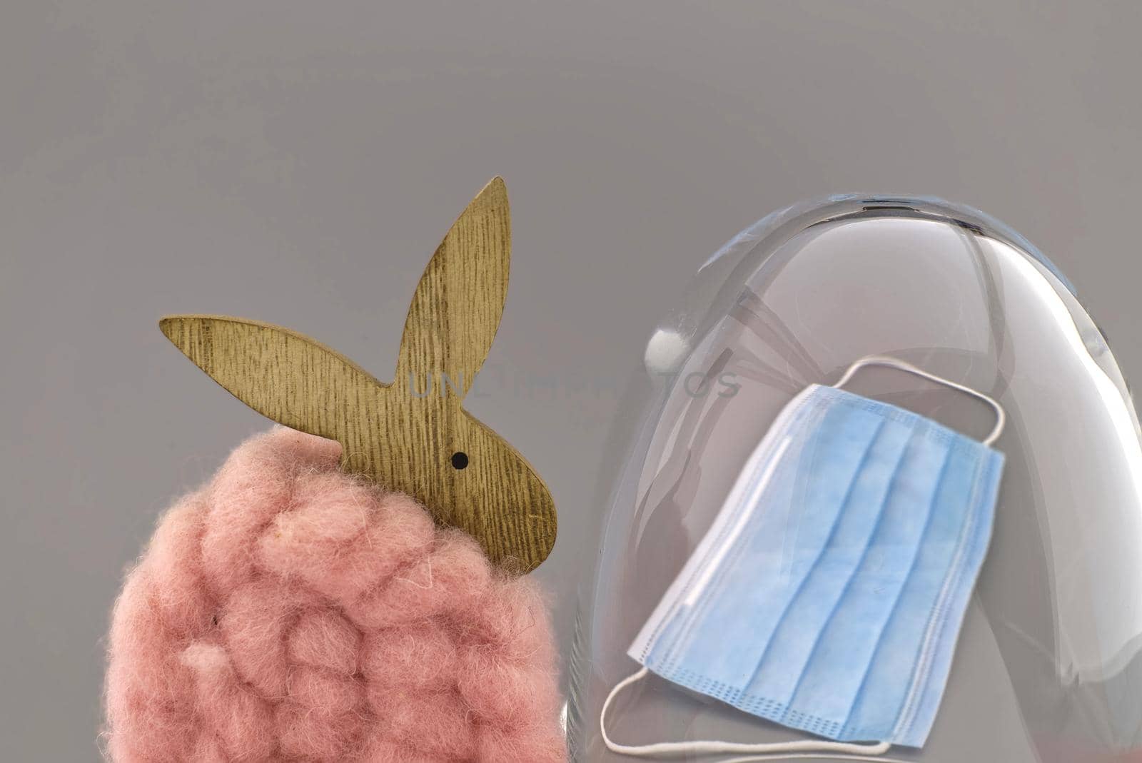 Woolly Easter bunny with protective face mask and perspex visor conceptual of the Covid-19 or coronavirus pandemic