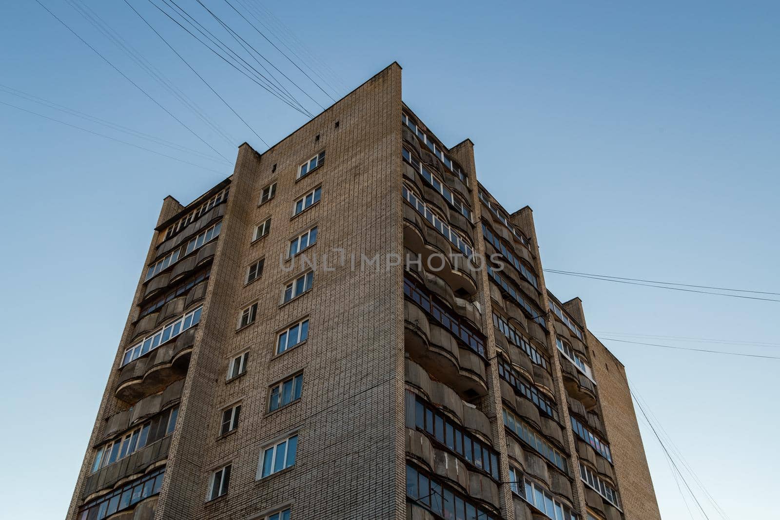 typical mid-russian silicate brick high rise condominium residential building, upward view on blue sky background