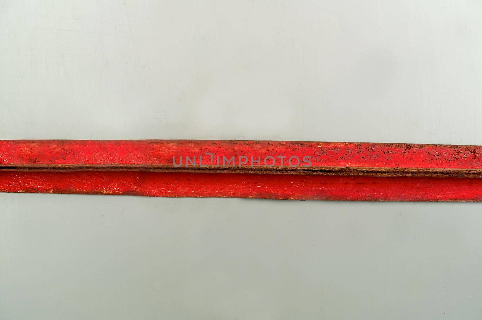 Metal rusty plate aged by time is red on a light background.Texture or background