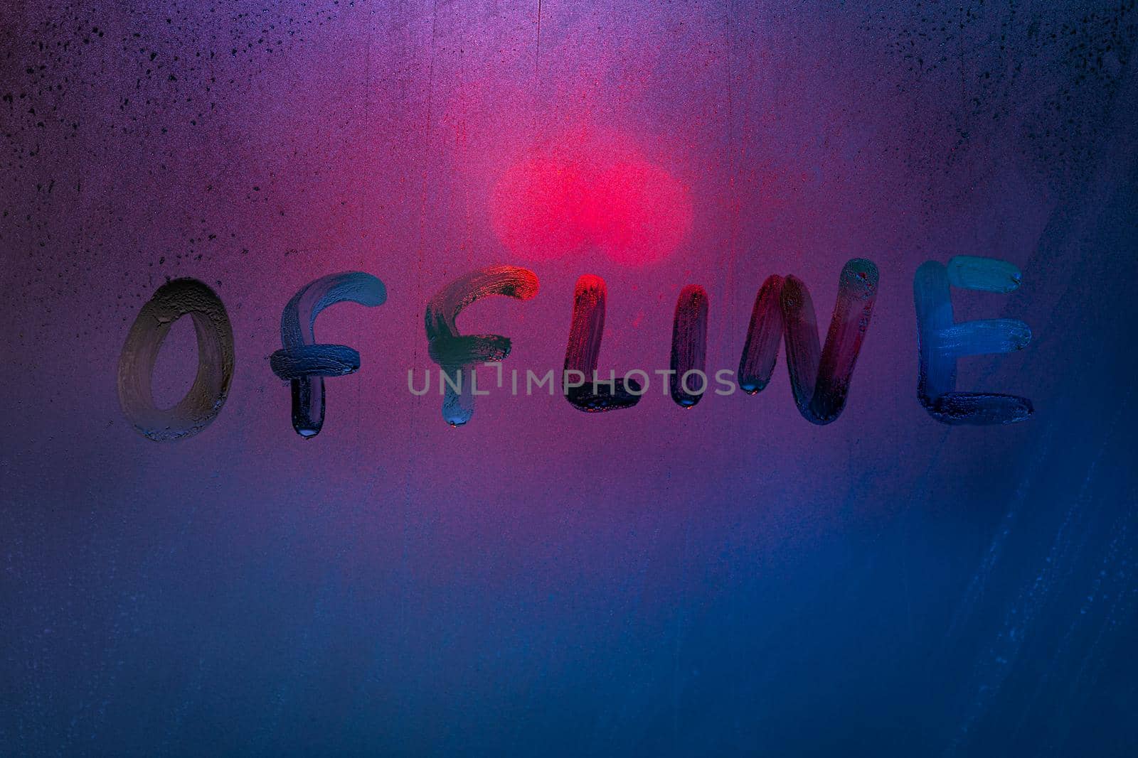 the word offline handwrittern on foggy glass with cold neon blue back light