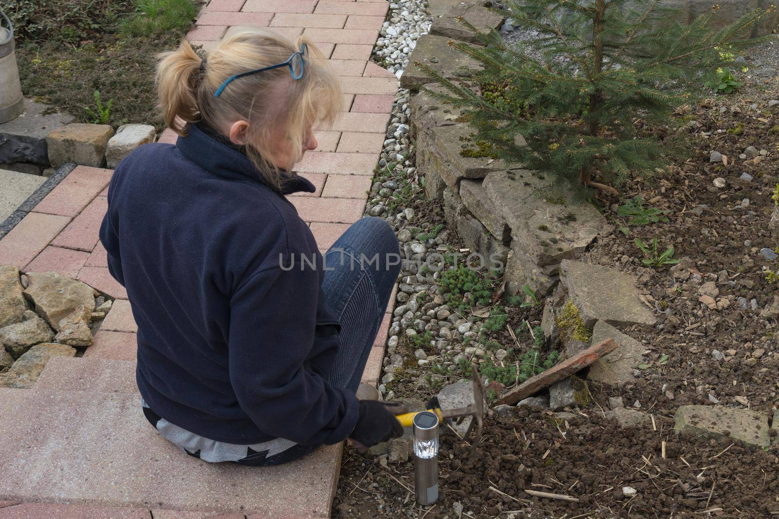 Woman is planting flowers in the garden    by JFsPic