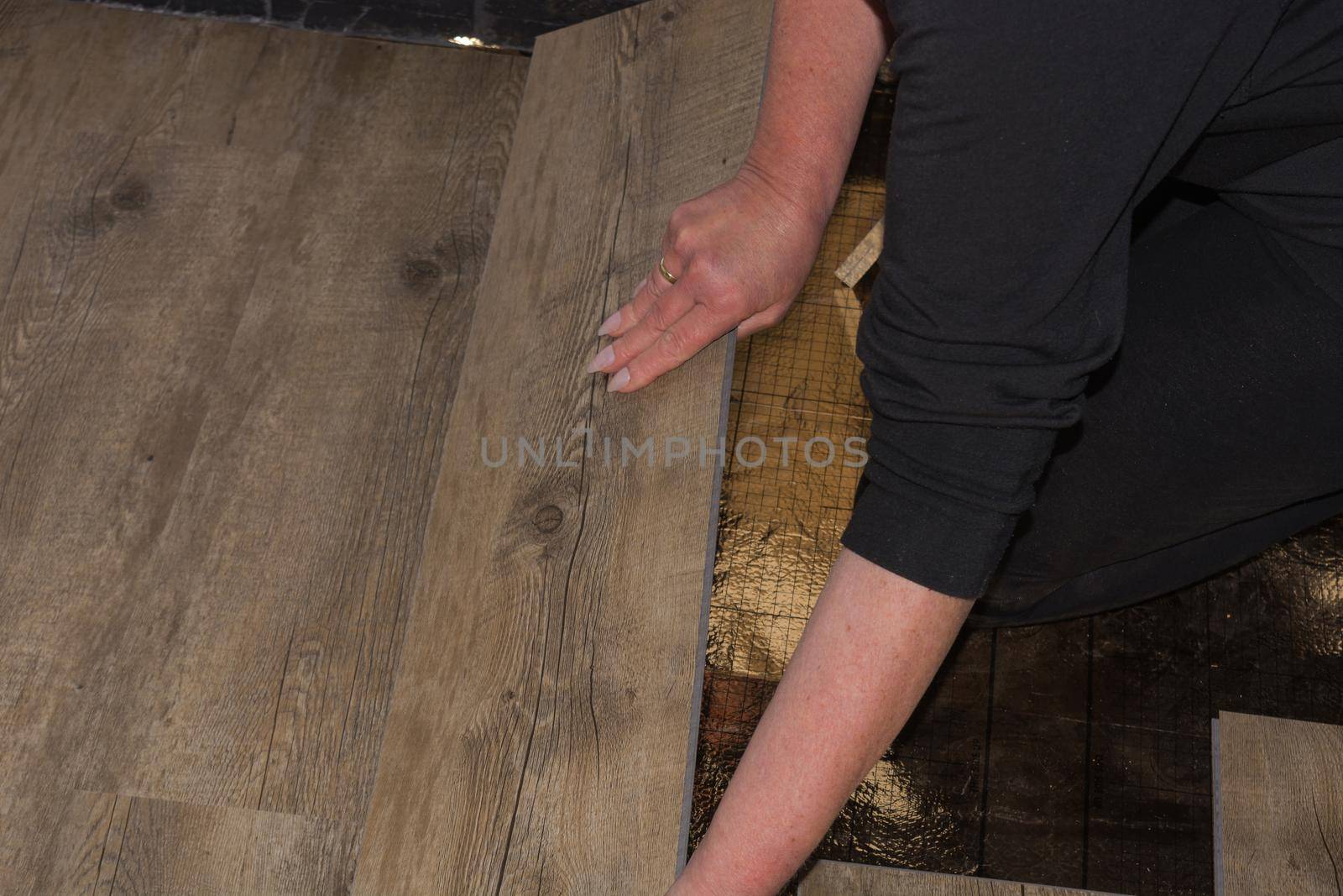 Woman is laying laminate floor. repair concept by JFsPic