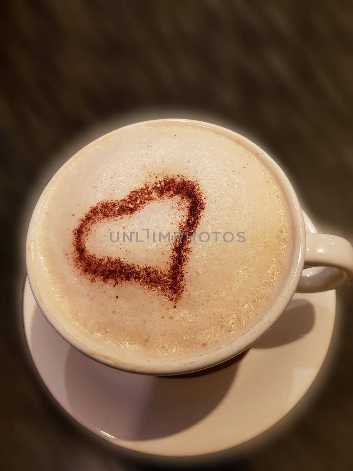 A cup of coffee on dark blurred background with motion blur. For example, a company name could easily be pasted on behind the cup.