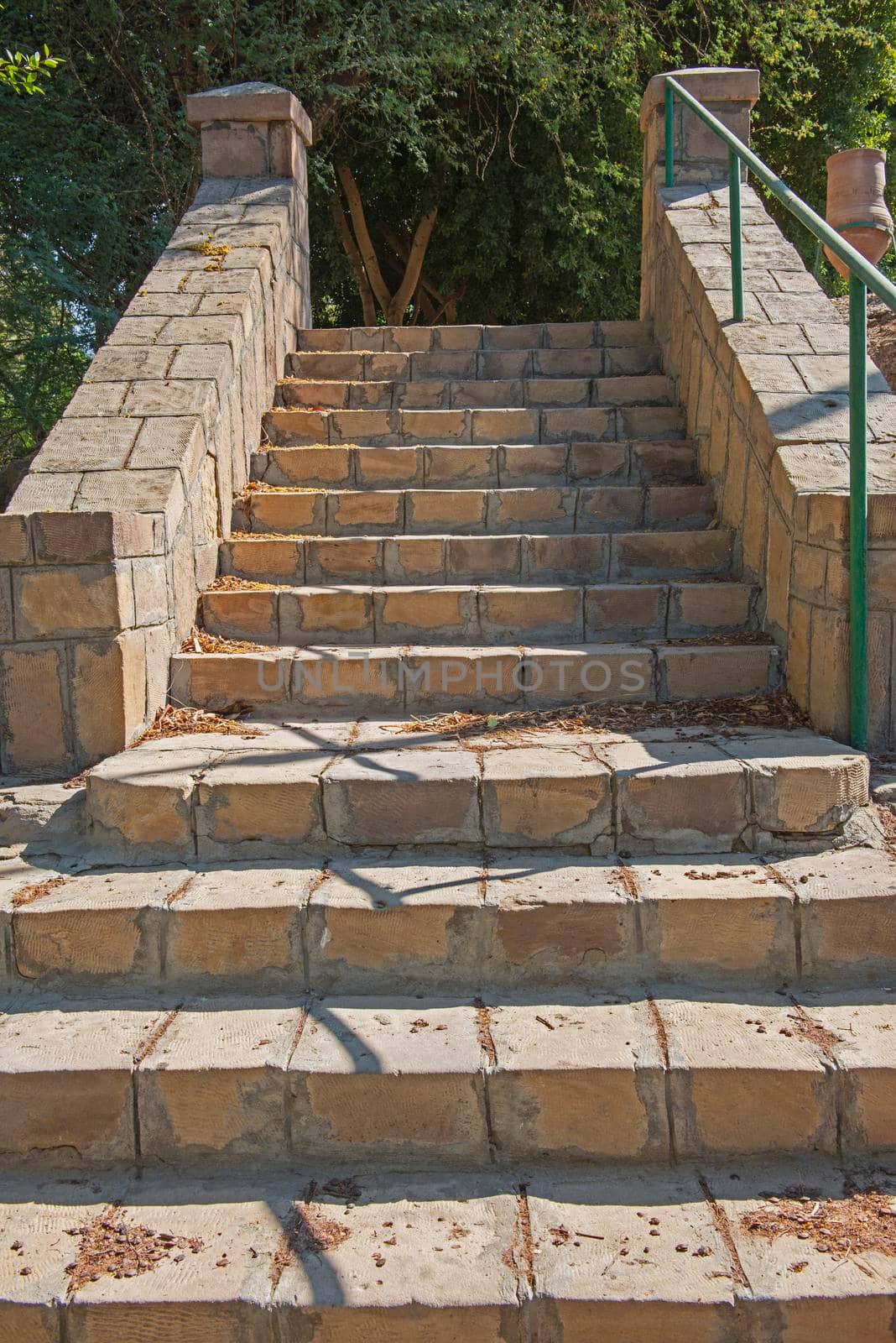 Closeup detail of stone paved steps on rural footpath walkway going upwards in formal garden grounds