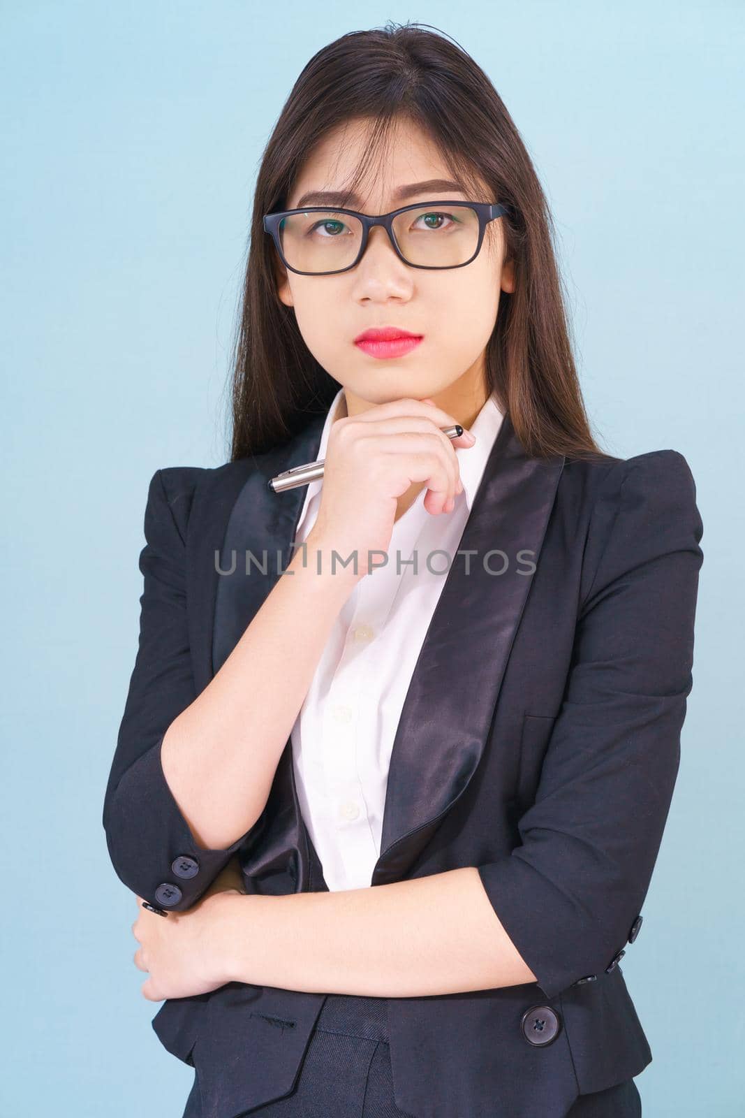 Young asian girl wearing suit with support hand on chin by stoonn