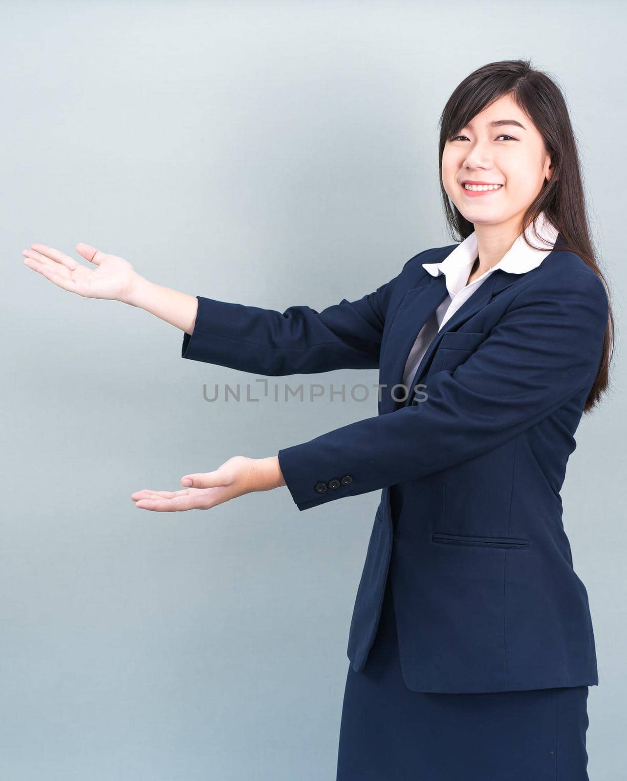 Asian woman in suit open hand palm gestures with empty space  by stoonn