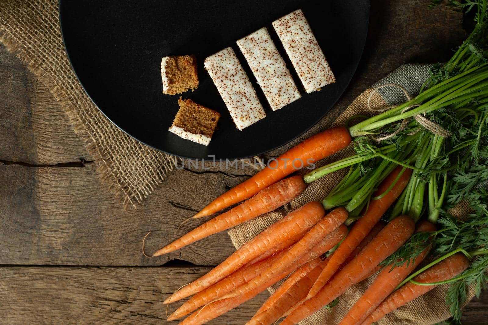 Fresh organic carrots, carrots English cakes in a box with canvas on antique wooden table. Rustic kitchen concept. Banner, poster, mock up. Grunge, vintage, rustic style