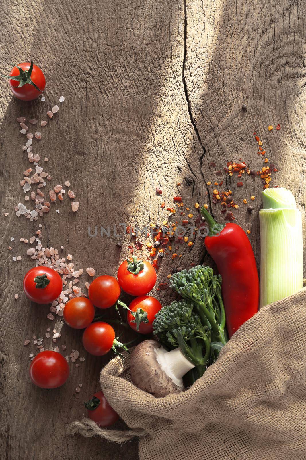 Diferent vegetables in canvas bag on wooden bakground. Ructic style of kitchen