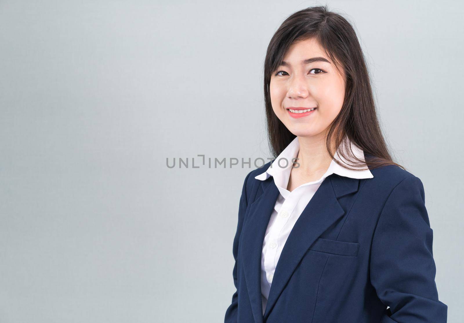 Portrait of asian business woman standing isolated on gray background