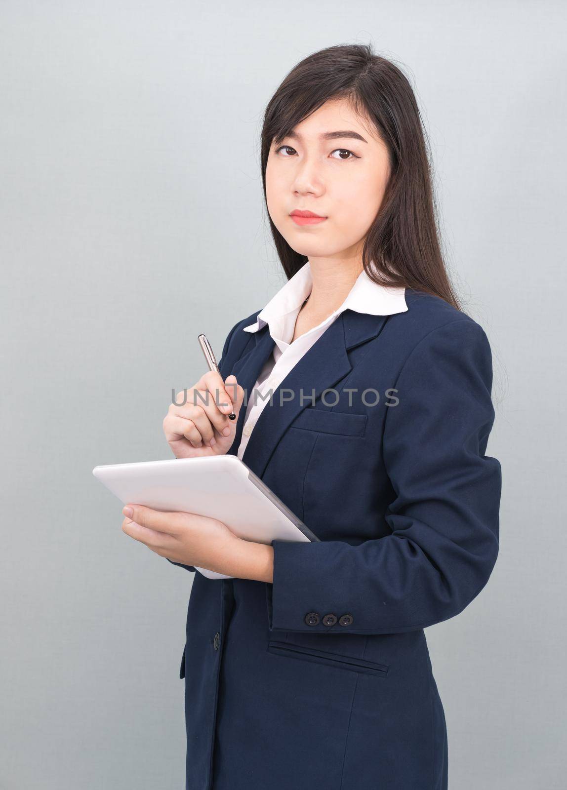 Woman in suit using computer digital tablet isolate on gray background