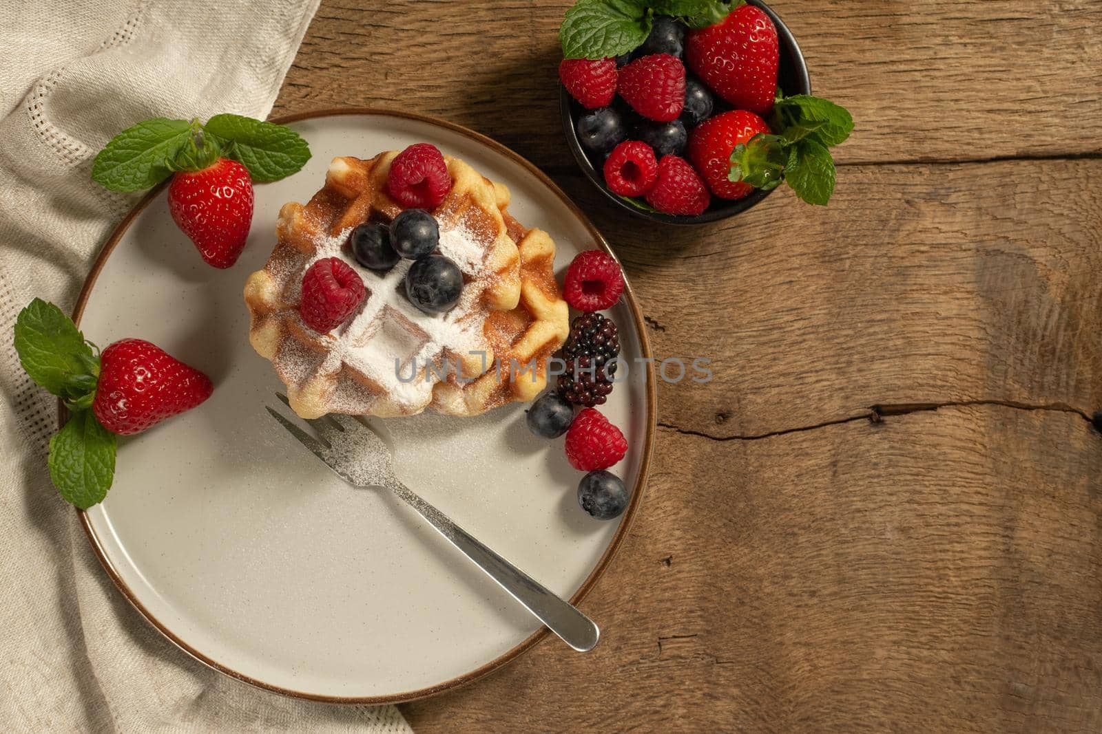 Belgian waffles with summer fruits on plate on dark wooden background. by NelliPolk