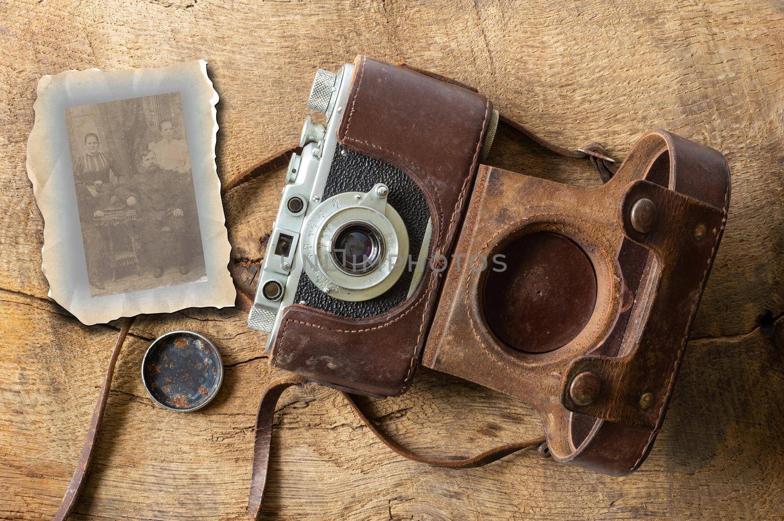 Vintage film camera with leather case on old wooden bakground by NelliPolk