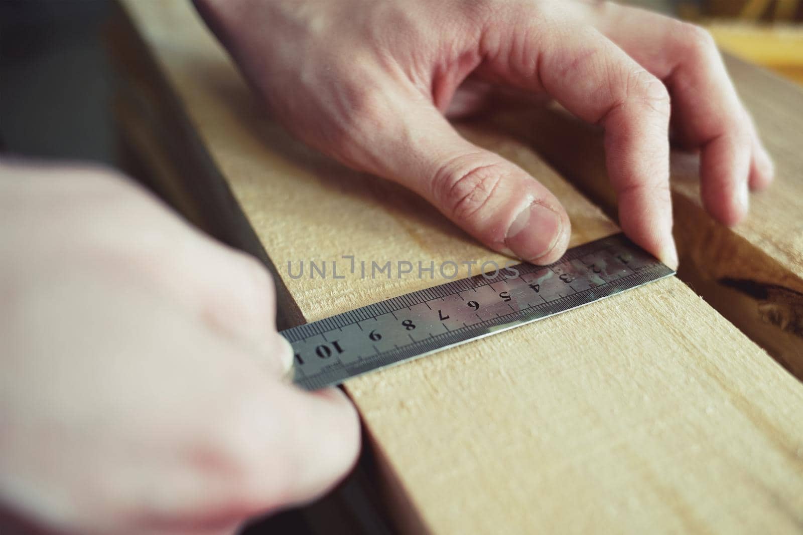 Construction and repair. Men's hands line measure the width of a wooden board. Hands with a close-up tool. Production control.