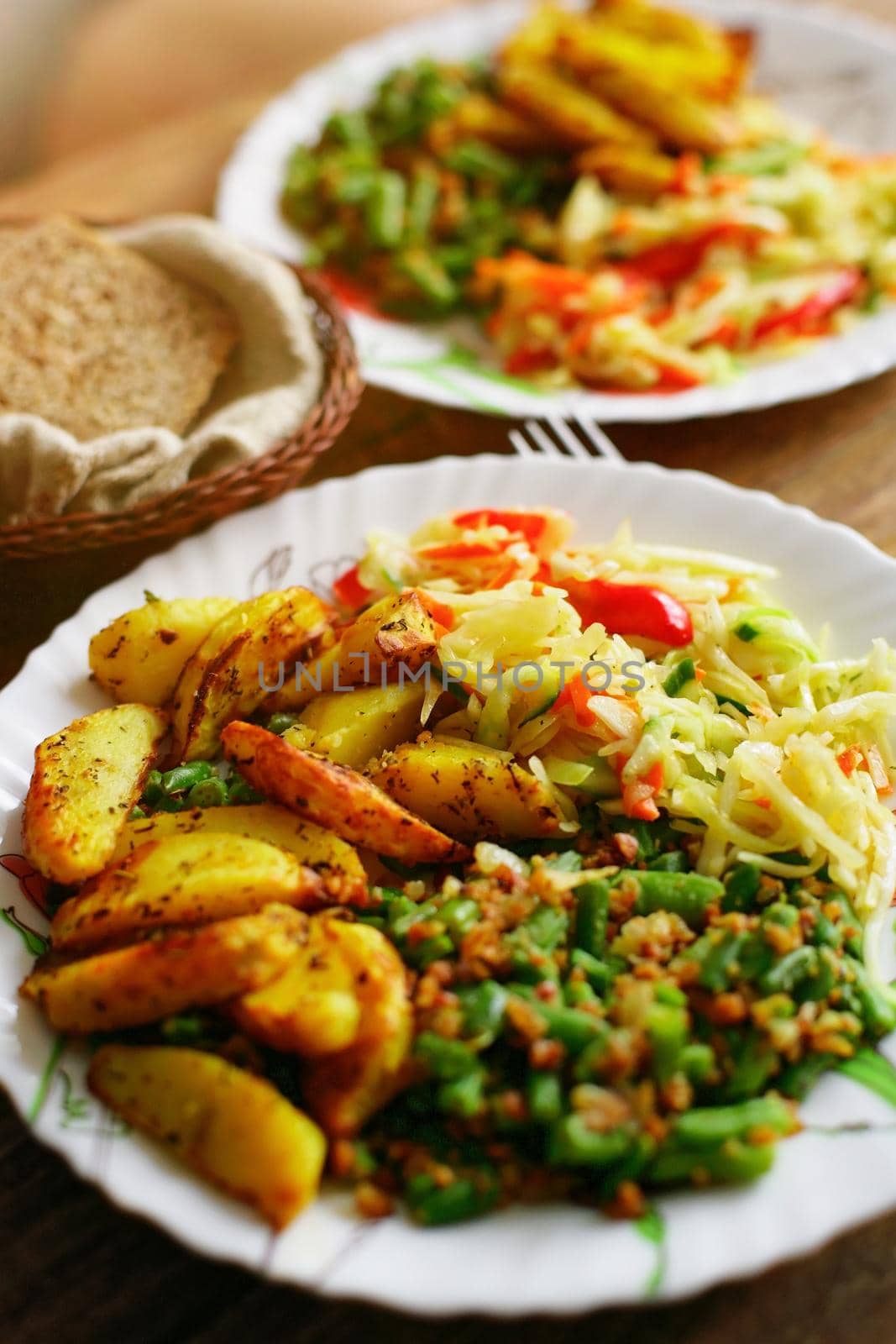 Food on a plate. Delicious and delicious homemade lunch: fried potatoes, string beans and a portion of salad. Top view by SergeyPakulin