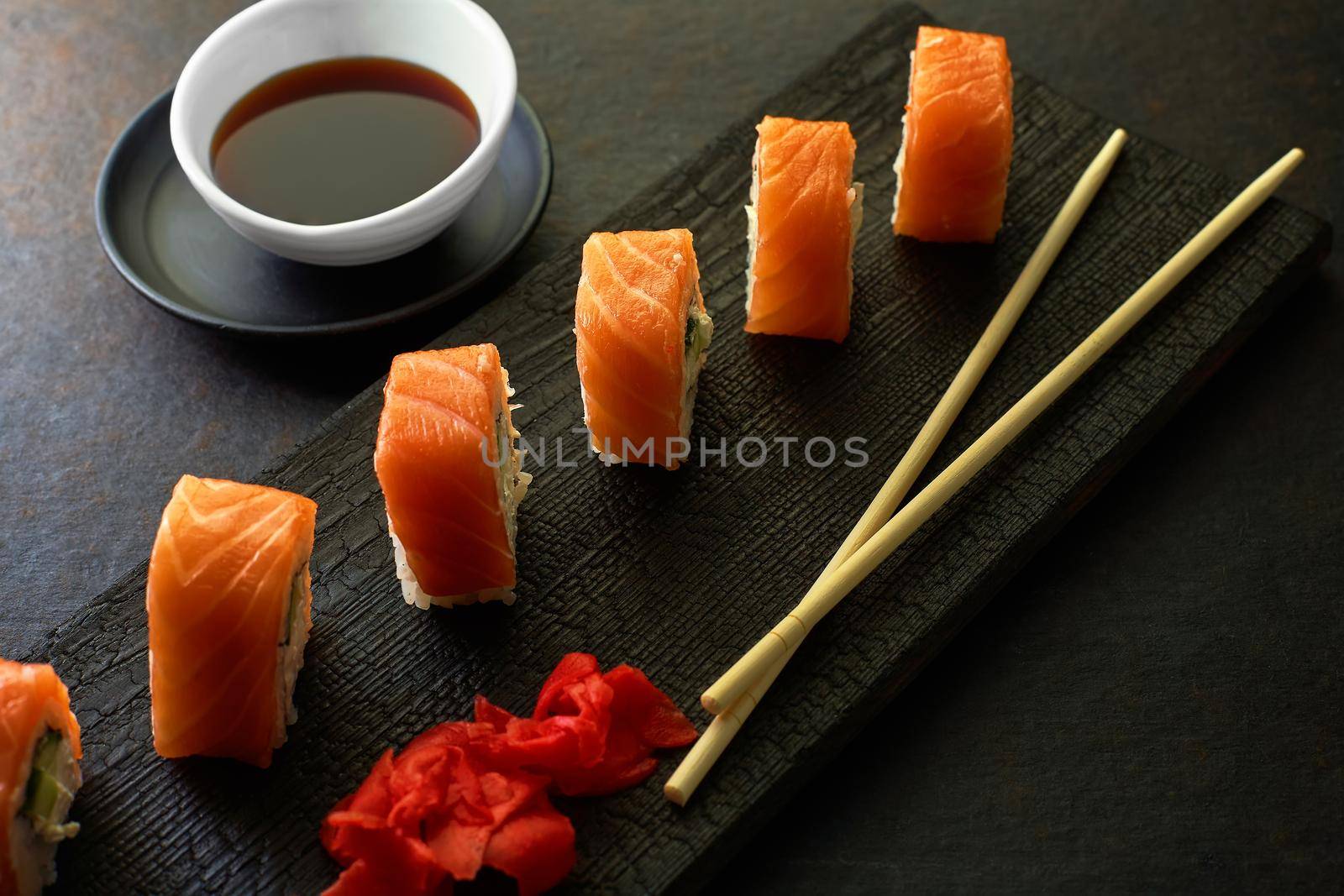 Sushi rolls. Dark style. Serving a meal at a Japanese restaurant. Top view with space to copy. Minimalism in marketing.