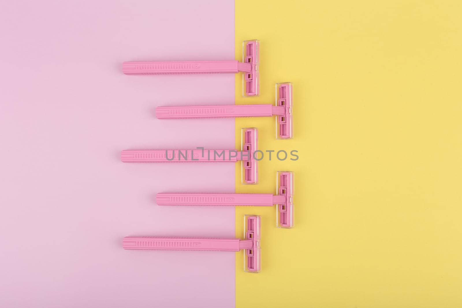 Pink razors on colored pink and yellow background by Senorina_Irina