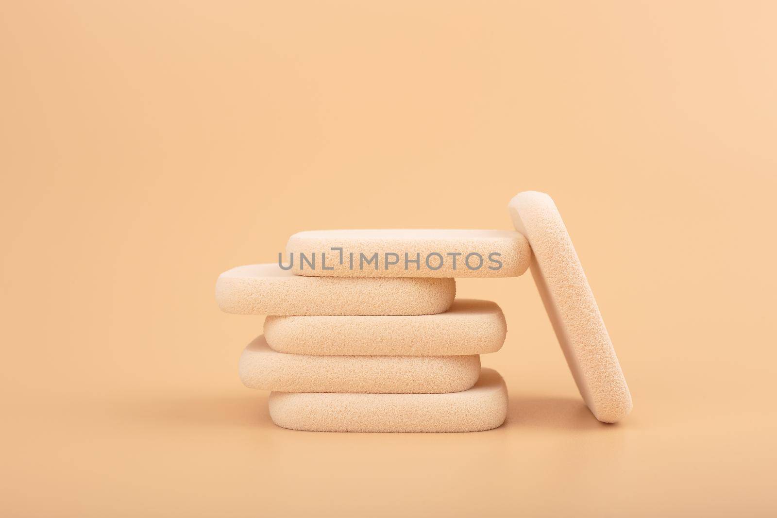 Stack of make up sponges for applying make up on beige background by Senorina_Irina