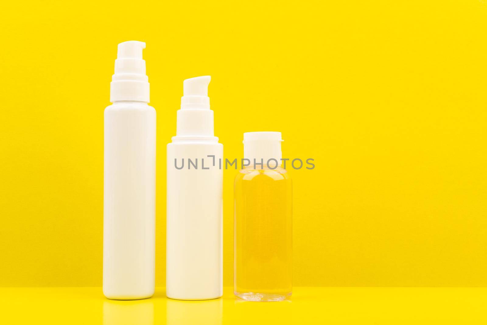 Set of cosmetic products for daily skincare against bright yellow background with space for text