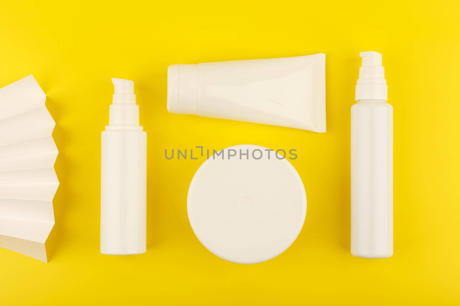 Bright yellow flat lay with set of cosmetic products for skin and body care on yellow background.Concept of daily skin and body care or summer treatment