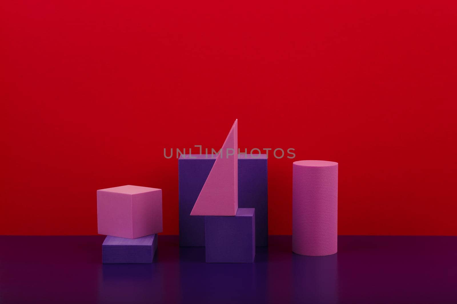 Abstract geometric composition with purple figures on purple shiny table against red background with copy space by Senorina_Irina