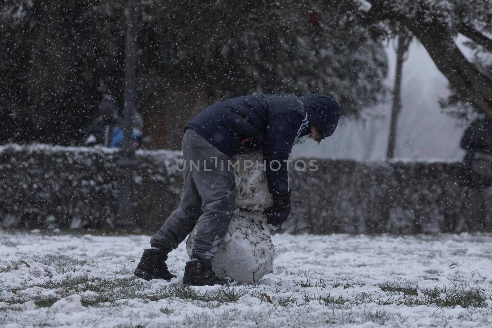 Children playing with snow and making snowmen, in Retiro park, Madrid. by alvarobueno