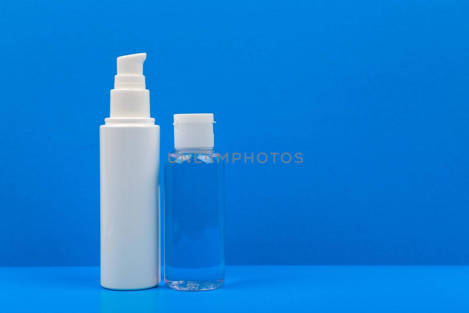 Face cream and lotion on blue table against blue background. Concept of hygiene and skincare with copy space by Senorina_Irina