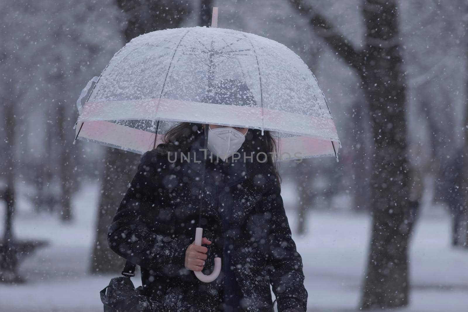 Young girl walks fast in the middle of the blizzard, Madrid. by alvarobueno