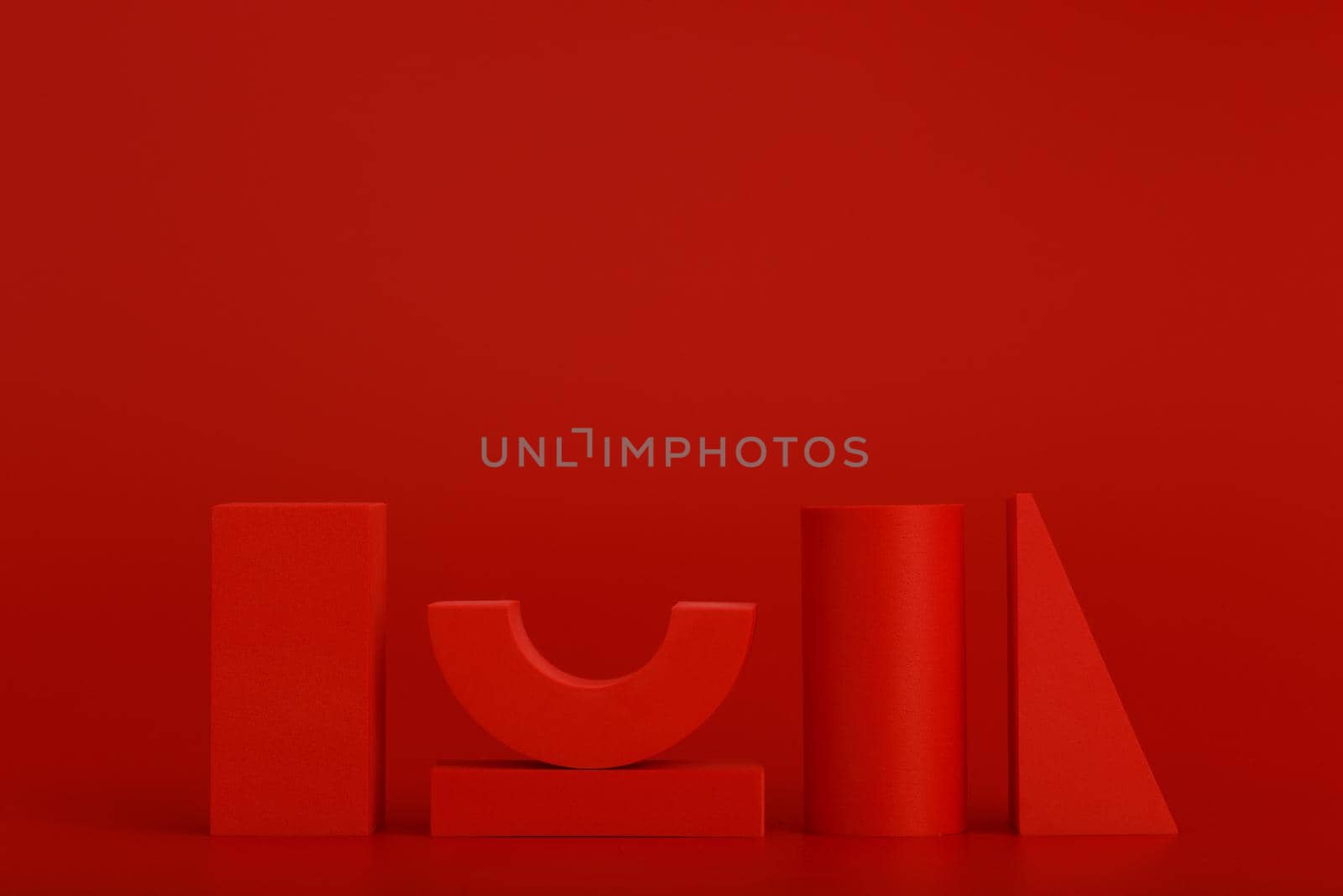Red abstract and minimalistic still life with red geometric figures against red background with space for text. Futuristic sample, advertising or banner concept