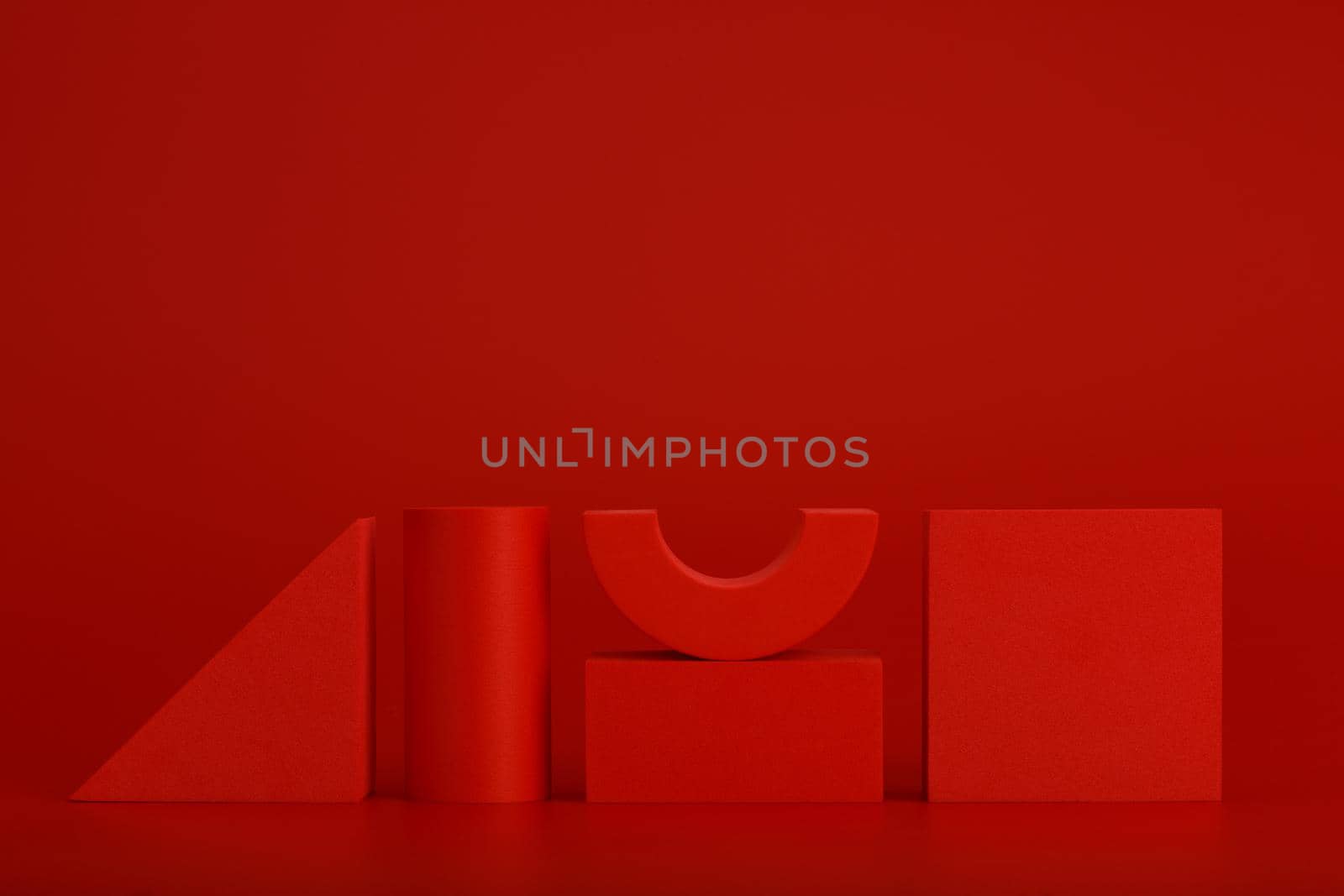Red triangle, cylinder, rectangular and square against red background with space for text