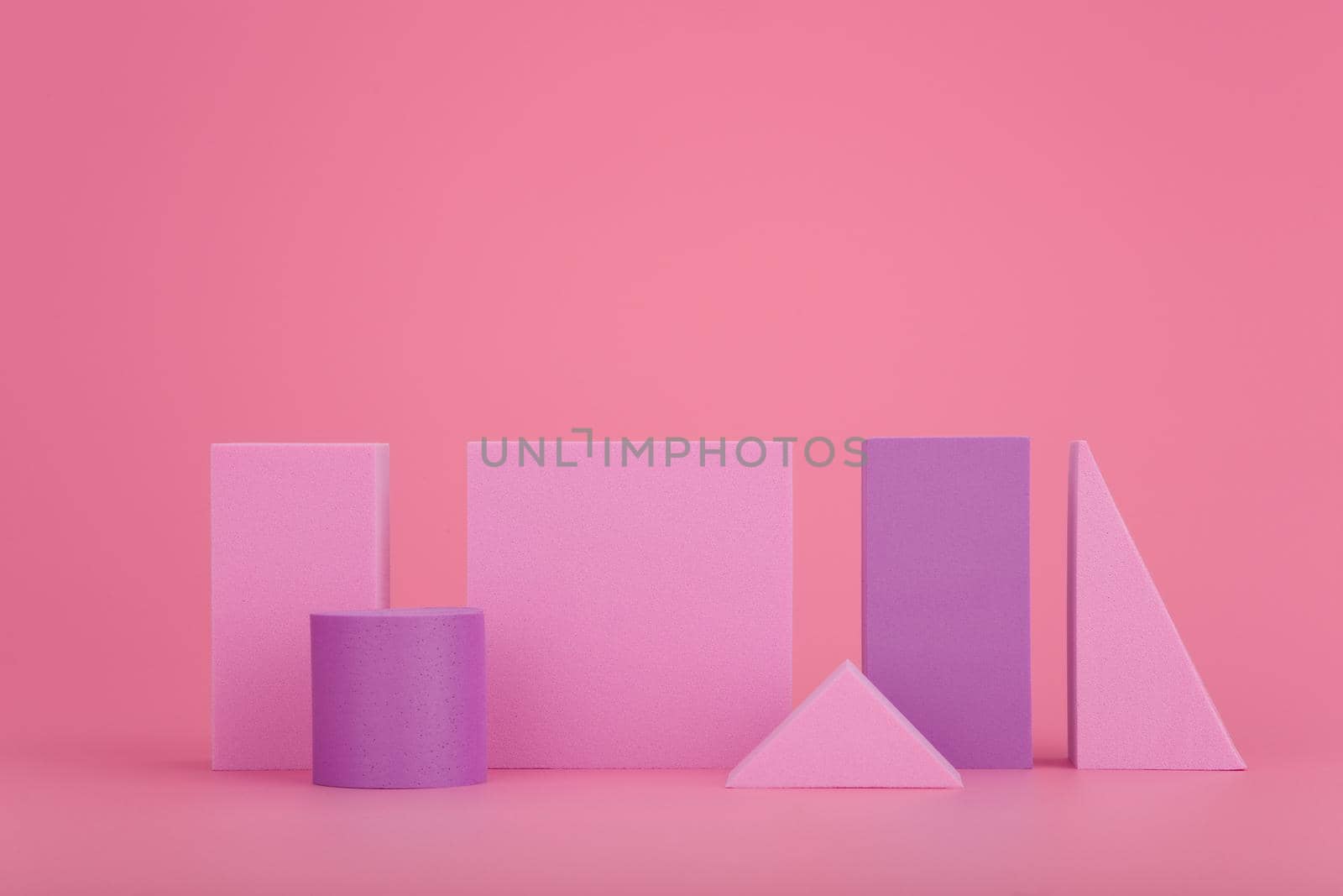Abstract geometric composition with pink and purple geometrical figures on bright pink background with copy space. High quality photo