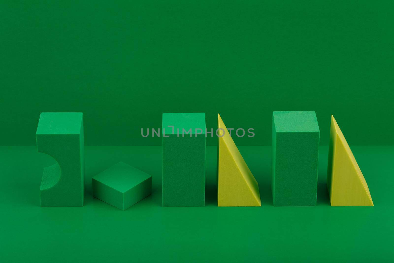 Futuristic duotone abstract still life with green and yellow geometric figures on green background with space for text by Senorina_Irina