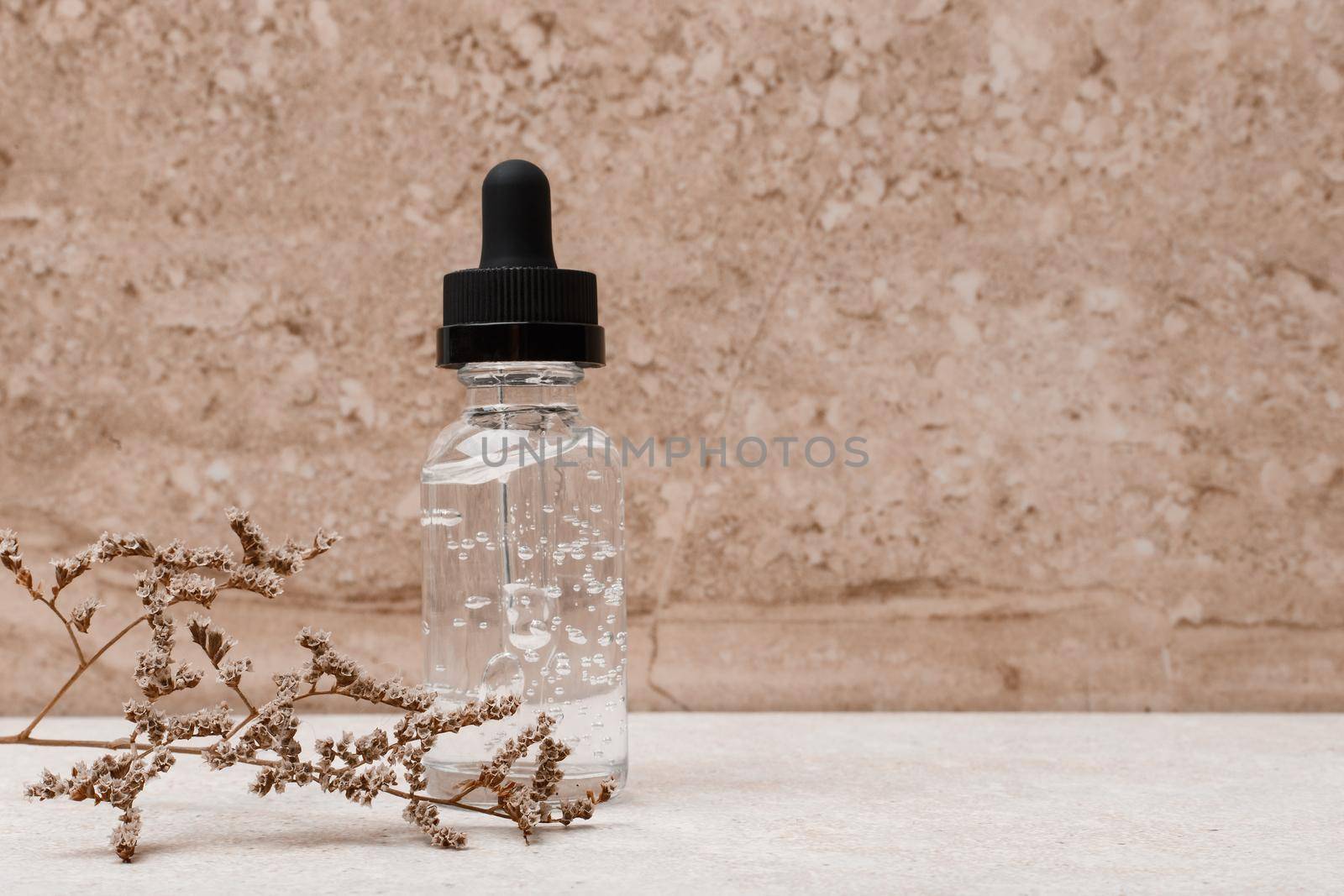 Skin serum in transparent bottle with black cap against marble background with space for text by Senorina_Irina