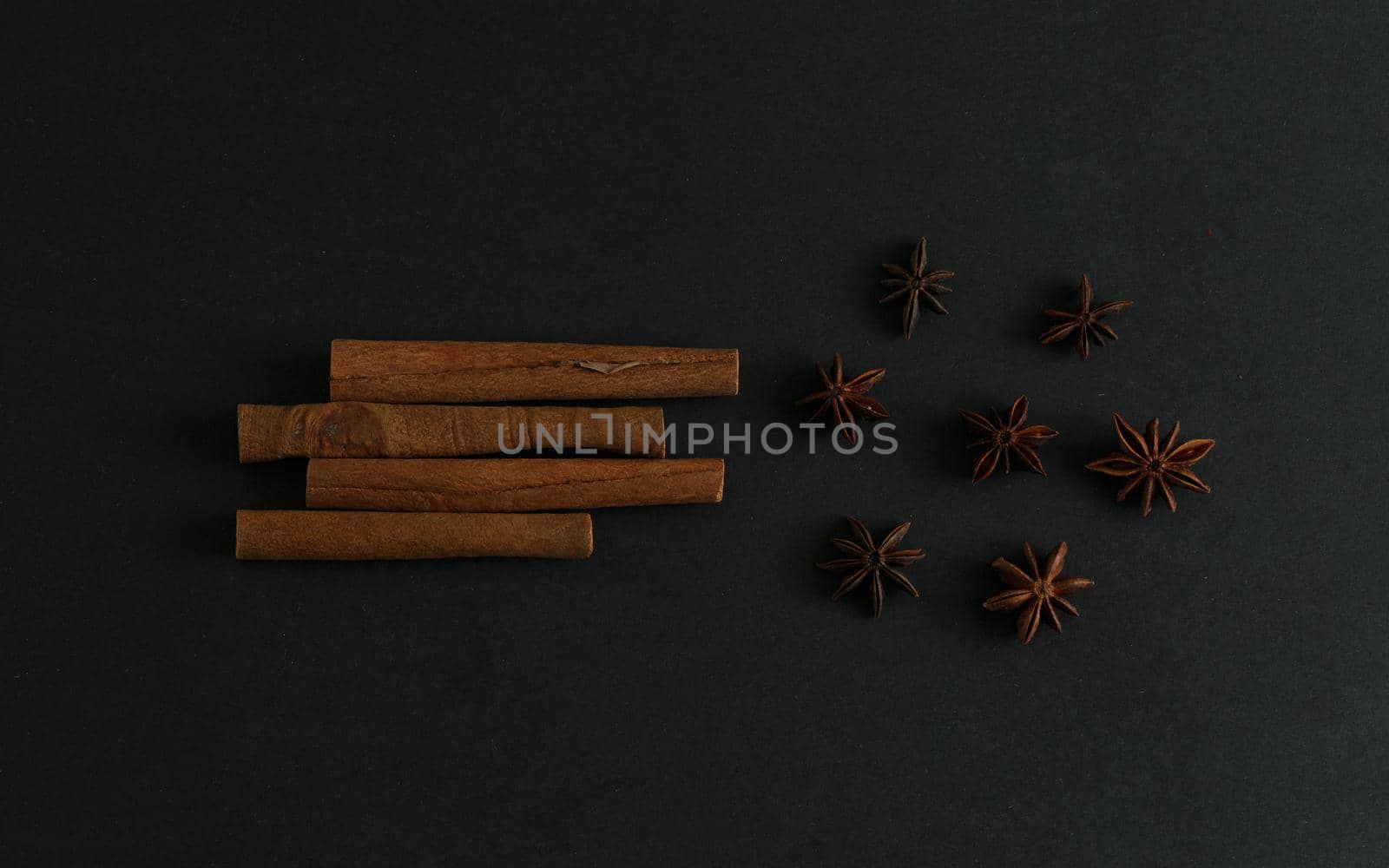 Cinnamon sticks and anise stars flatlay on black background by Senorina_Irina