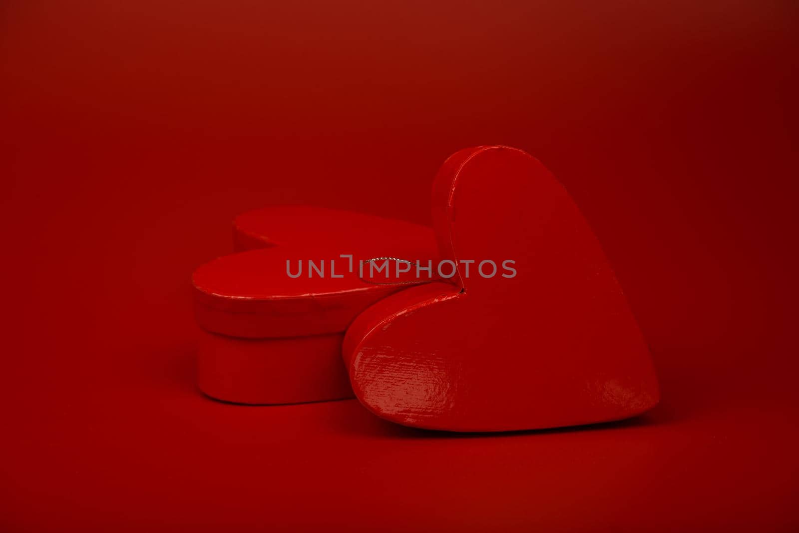 Two heart shaped gift boxes on red background by Senorina_Irina