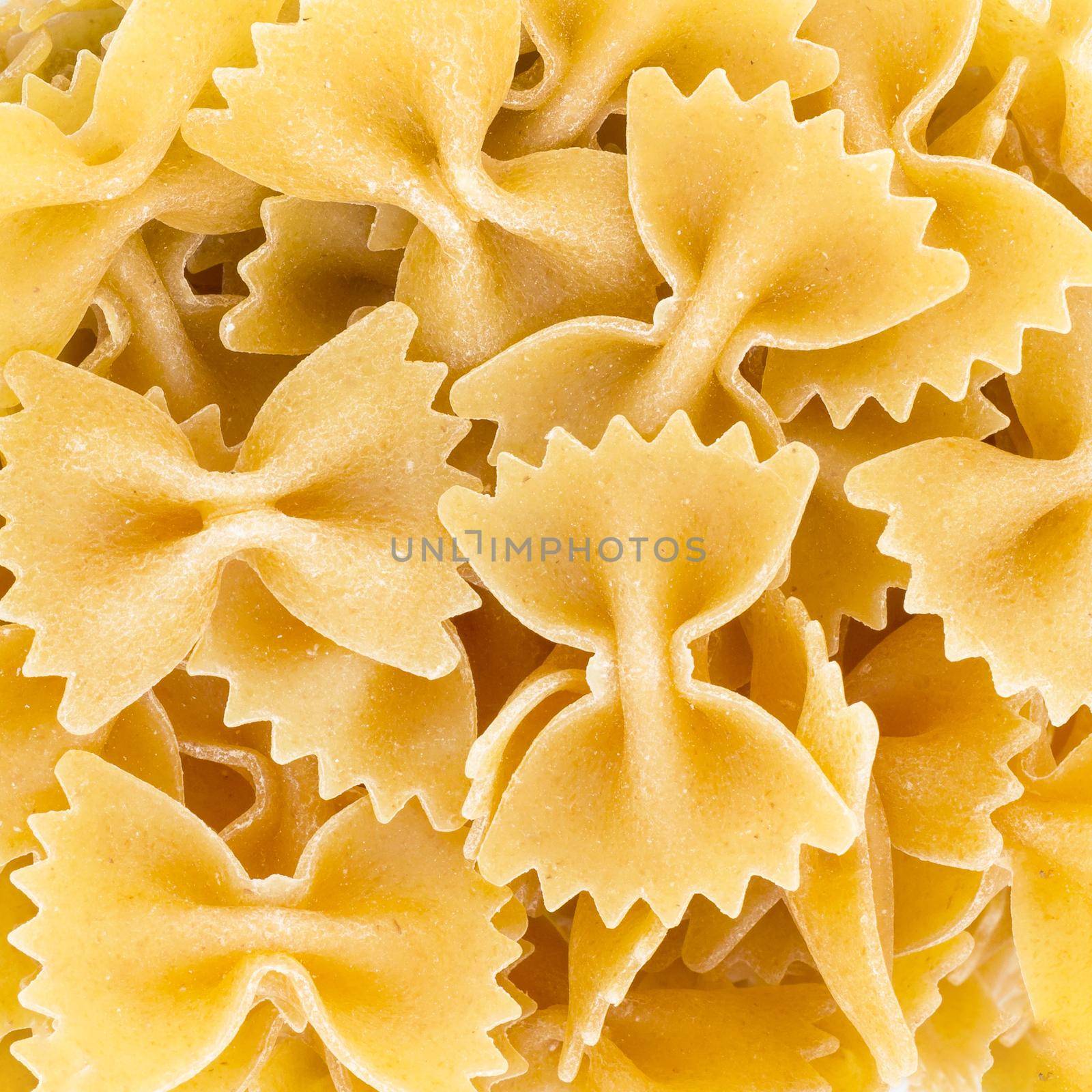 Uncooked farfalle pasta background. Whole wheat pasta.