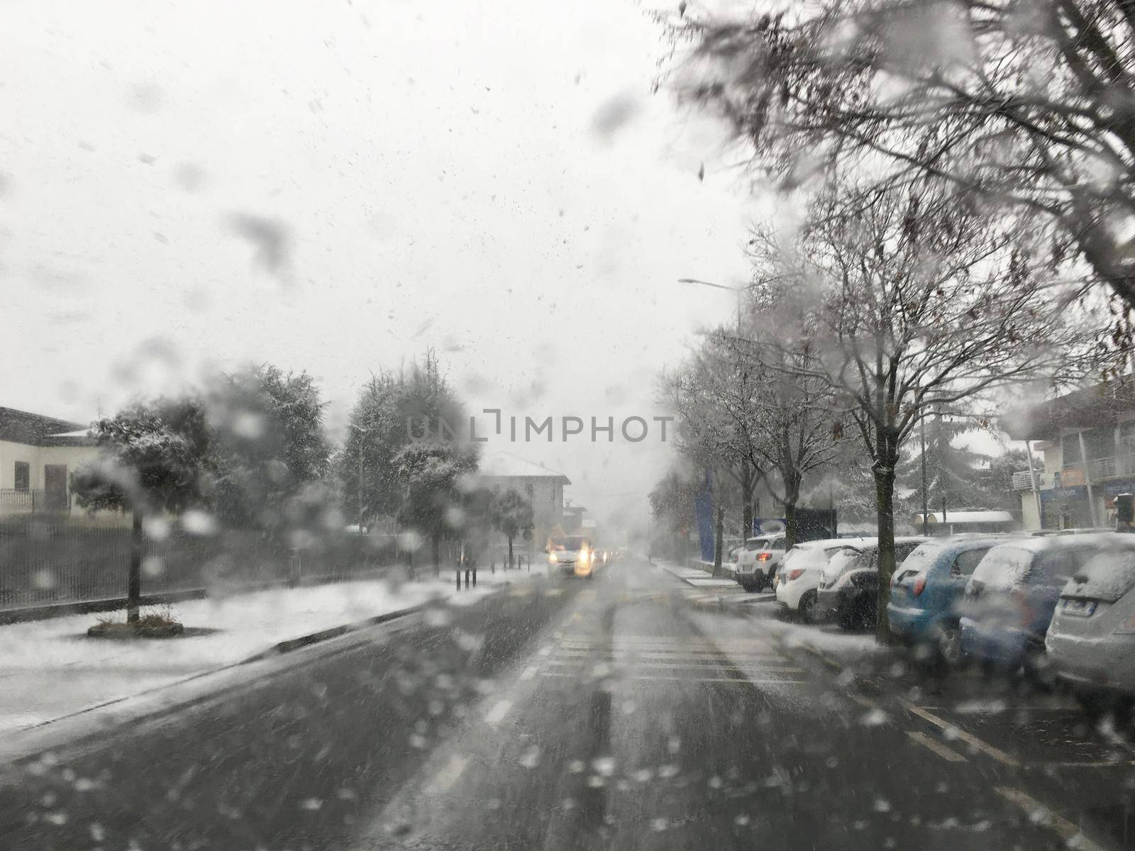 Snow in the city on the road view from the car by germanopoli