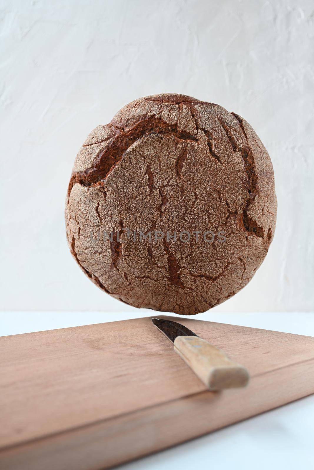 black bread on wooden board and white background. levitation.