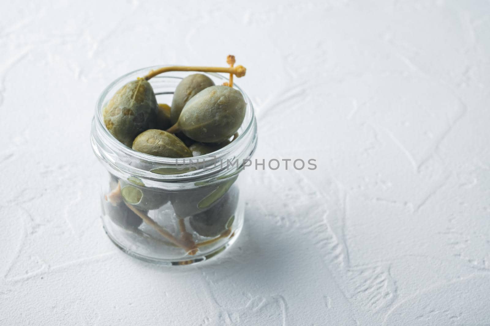 Organic pickled, canned capers, on white background with copy space for text