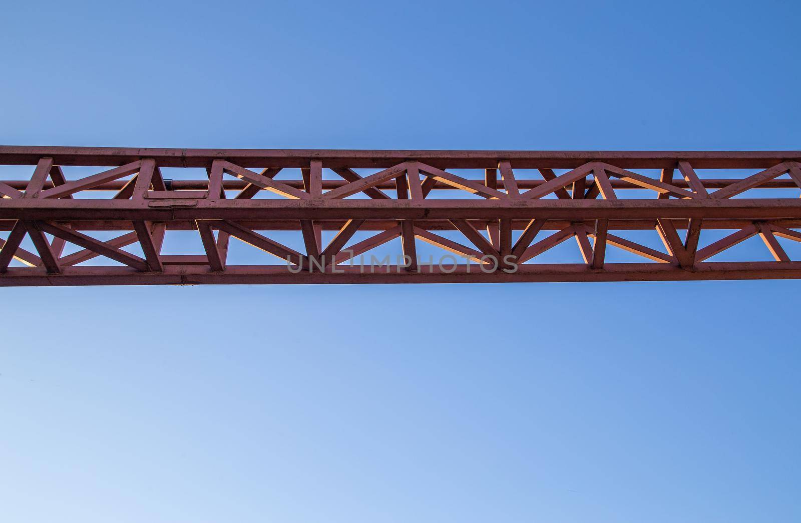 straight red steel welded girder beam on blue sky background